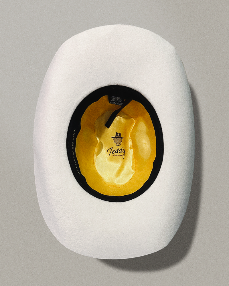 Teddy Headwear silk lining interior and adjustable sweatband with exterior hat band with debossed metal branding available in two colors, brown and cream, made for unisex and designed in America.