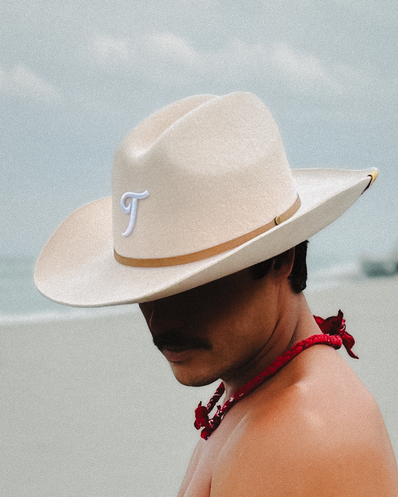 Male model wearing cream Teddy Headwear Texas monogram artwork and design in South Florida. 